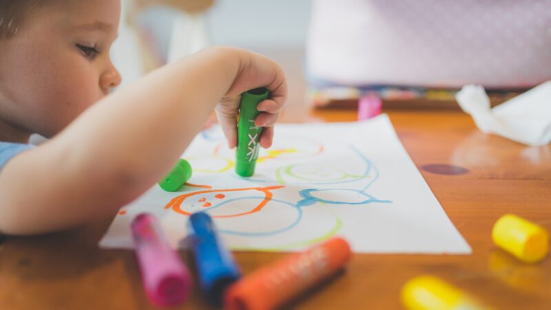 Criança desenhando durante atividade terapêutica em atendimento psicossocial.
